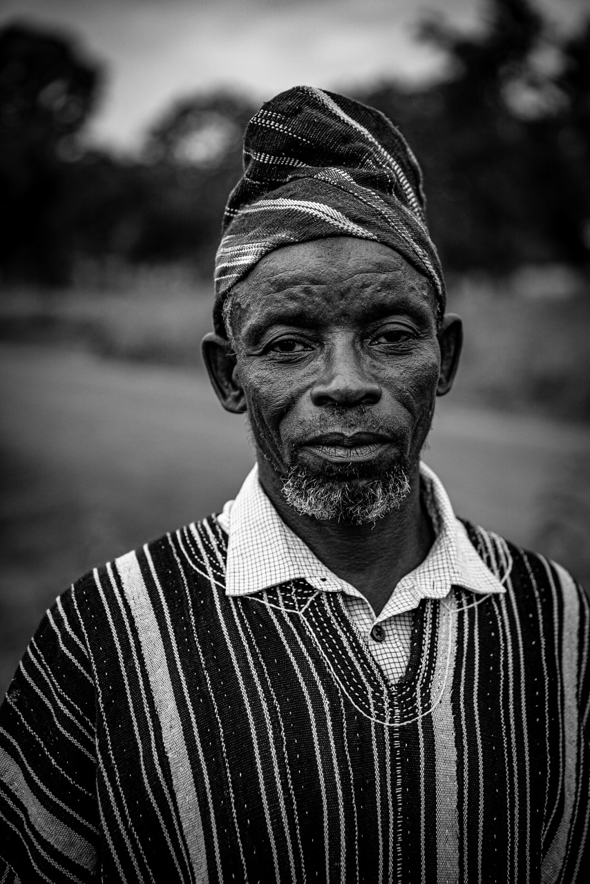 A local elder named Amadu standing beside a newly built clean water borehole