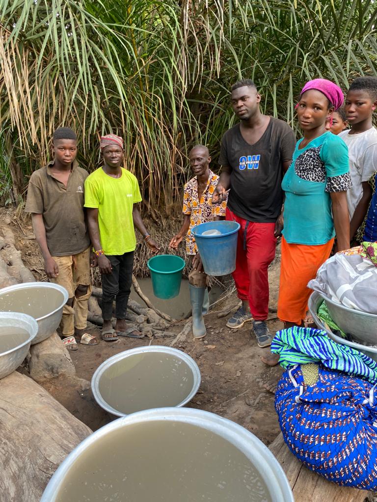 A woman and children carrying clean water containers from a village collection point